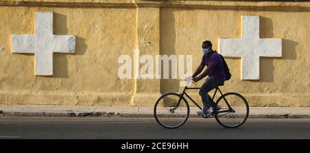 Havanna, Kuba. August 2020. Ein Mann fährt mit dem Fahrrad entlang der Mauer des Colon-Friedhofs von Havanna. Aufgrund der Zunahme neuer Corona-Fälle wird in Havanna vom 1. Bis 15. September, zunächst zwischen 19 und 17 Uhr, eine Sperrstunde verhängt. Quelle: Guillermo Nova/dpa/Alamy Live News Stockfoto