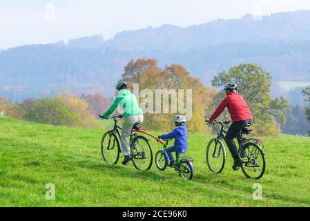 Junge Familie hat viel Spaß beim Radfahren in Herbstliche Natur Stockfoto