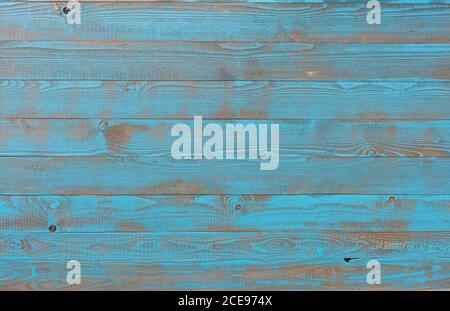 Eine Wand aus hellblau lackiertem Fichtenholz in Vintage-Stil, in dem die Holzstruktur durchleuchtet Stockfoto