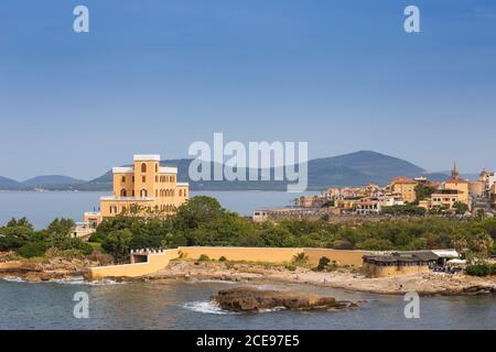 Italien, Sardinien, Alghero, Strand Las Tronas, mit Altstadt im Hintergrund Stockfoto
