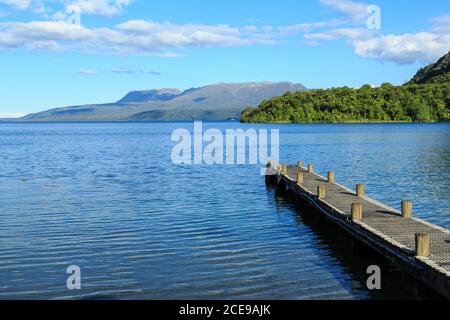 Schöner See Tarawera, Neuseeland, von der Kotukutuku Bay aus gesehen. Ein Pier weist auf den Mount Tarawera, einen Vulkan Stockfoto