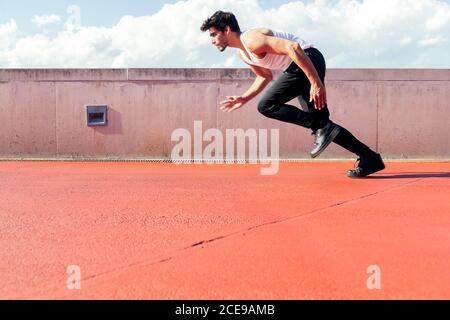 Schöner männlicher Läufer läuft zum Sprint, Konzept des urbanen Sports und gesunden Lebensstils, Copy Space for Text Stockfoto