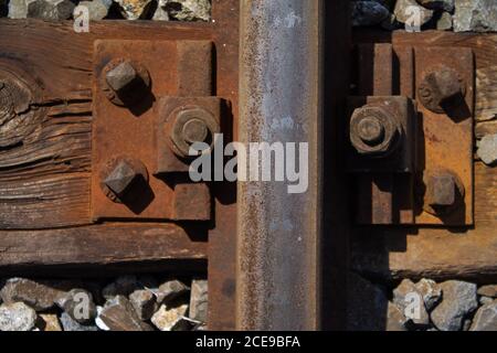 Befestigungsschrauben der Schienenbahn im Gleisbett. Wie Sie sehen können, wurde es vor langer Zeit montiert. Stockfoto
