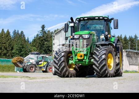 BAYERN / DEUTSCHLAND - 20. AUGUST 2020: John Deere Traktor mit Ladewagen, der an einer Biogasanlage arbeitet Stockfoto