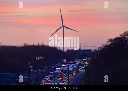 Stau auf der Autobahn A1/M bei Sonnenaufgang durch Strom Windpark Leeds uk Stockfoto