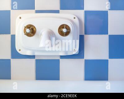 Antike Innenwasserhahn im Bad auf der blauen Und weiße Fliesenwand Stockfoto