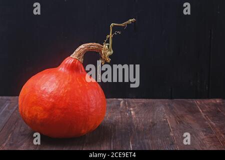 Hokkaido Pumpkin auf dem Holztisch mit schwarzem Hintergrund. Stockfoto