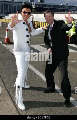 Glasgow Prestwick Airport Ayrshire im Vereinigten Königreich ist der einzige Ort, der von 'The King of Rock & Roll Elvis Preseley. Im nationalen Dienst wurde Sergent Presley am 3. März 1960 von schreienden Fans begrüßt, nachdem sein Flugzeug zum Tanken angehalten hatte : Photo zeigt Elvis Presley ( aka Gordon Hendricks Gewinner der ITV Stars in Their Eyes 2005 ) mit Mark Rodwell Chief Executive von Glasgow Prestwick Stockfoto