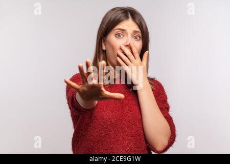 Nein, ich fürchte! Portrait von Panik verängstigten Mädchen in zotteligen Pullover gestikuling stoppen und suchen überrascht mit verängstigten Augen, deckt den Mund nicht zu sh Stockfoto