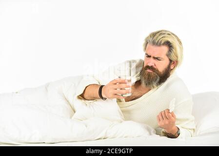 Hipster trinken Wasser Nehmen Sie Medikamente. Kopfschmerz Kater. Kater Heilmittel. Überschlafen kann Körper in Gefahr für metabolische Probleme setzen. Kater-Konzept. Mann schmerzhaft Leiden Gesicht Aufwachen am Morgen. Stockfoto