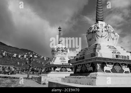 Buddhistische Stupas mit Gebetsfahnen über schneebedeckten Himalaya unter blauem Himmel zwischen Manali und Kaza, Himachal Pradesh, Indien. Stockfoto