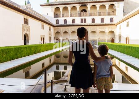 Maskierte Touristen besuchen den Comares Palast der Alhambra in Granada. Stockfoto