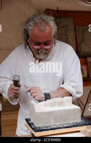 MONTBLANCH, SPANIEN - 28. APRIL 2018: Der alte Mann macht auf traditionelle Weise eine Marmorskulptur beim Montblanc Medieval Week Fest Stockfoto