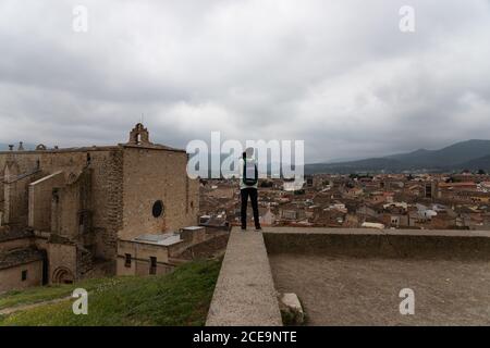 MONTBLANCH, SPANIEN - 28. APRIL 2018: Junger Mann, der an einem bewölkten Tag Fotos von der Landschaft des Dorfes und der Berge macht Stockfoto