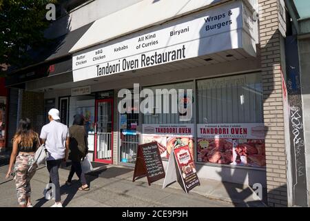 Menschen, die am indischen Restaurant Tandoori Oven im Punjabi Market District an der Main Street, Vancouver, BC, Kanada, vorbeigehen Stockfoto