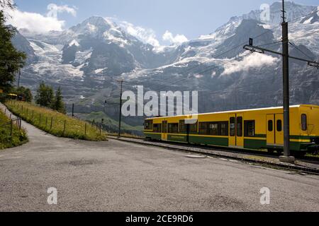 Lauterbrunnen, Berner Oberland, Schweiz - 3. August 2010 : Gelber Zug von der Wengernalpbahn im Bahnhof Wengernalp mit Schneedecke Stockfoto