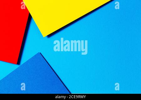 Abstrakte Farbpapiere Geometrie flach Lay Komposition Hintergrund mit blauen, gelben und roten Farbtönen Stockfoto