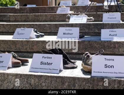 Ottawa, Kanada. August 2020. Schuhe von Angehörigen, die durch die Opiatepidemie in der Stadt gestorben sind. Der International Overdose Awareness Day (IOAD) ist ein globales Ereignis, das jedes Jahr stattfindet und das Ziel hat, das Bewusstsein für Überdosierung zu schärfen und das Stigma eines drogenbedingten Todes zu reduzieren. Sie erkennt auch die Trauer an, die Familien und Freunde empfinden, die sich an diejenigen erinnern, die durch eine Überdosis von Drogen mit Tod oder bleibender Verletzung begegnet sind. Kredit: Meanderingemu/Alamy Live Nachrichten Stockfoto