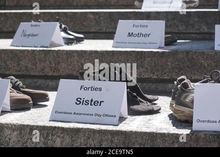 Ottawa, Kanada. August 2020. Schuhe von Angehörigen, die durch die Opiatepidemie in der Stadt gestorben sind. Der International Overdose Awareness Day (IOAD) ist ein globales Ereignis, das jedes Jahr stattfindet und das Ziel hat, das Bewusstsein für Überdosierung zu schärfen und das Stigma eines drogenbedingten Todes zu reduzieren. Sie erkennt auch die Trauer an, die Familien und Freunde empfinden, die sich an diejenigen erinnern, die durch eine Überdosis von Drogen mit Tod oder bleibender Verletzung begegnet sind. Kredit: Meanderingemu/Alamy Live Nachrichten Stockfoto