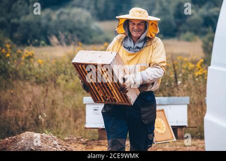 Portrait eines Imkers in Schutzkleidung mit Hive-Rahmen. Bienenzuchtkonzept, Kopierraum Stockfoto