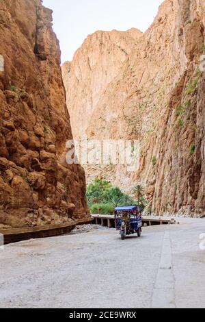 Blaues Fahrzeug auf einsamer Straße in sandiger Schlucht. Vertikale Außenaufnahme. Stockfoto