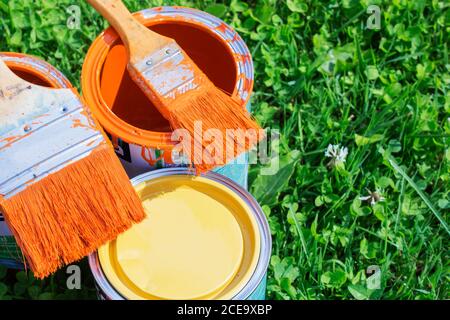 Farbdosen, Pinsel, leuchtend orange Farbe Stockfoto