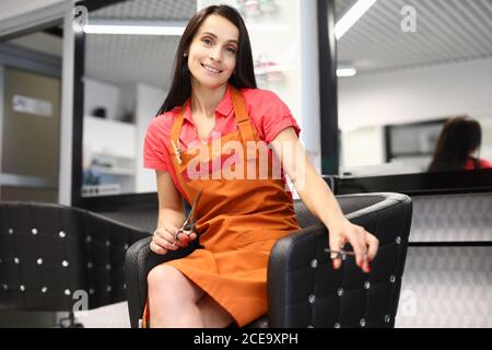 Professionelle Barber halten Schere in zwei Hand auf Innenhintergrund. Stockfoto