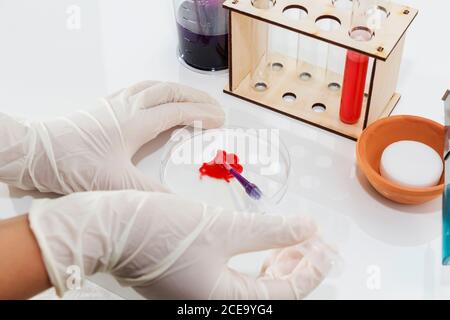 Die Hand des Arztes arbeitet mit einer Blutprobe, einem Fläschchen und einer Flasche. Stockfoto