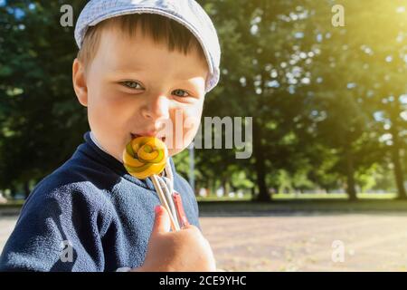 Der Junge isst einen köstlichen Lollipop.EIN süßer Junge leckt einen Lollipop. Stockfoto