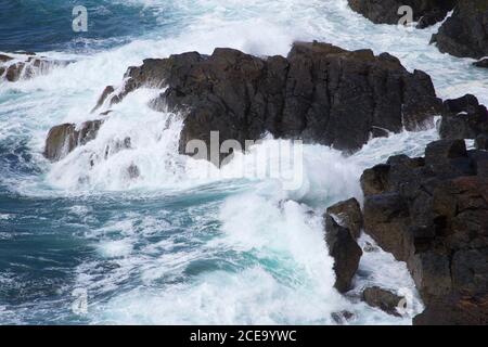 Wellen des Atlantischen Ozeans stürzen auf Felsen, Cornwall, Großbritannien Stockfoto