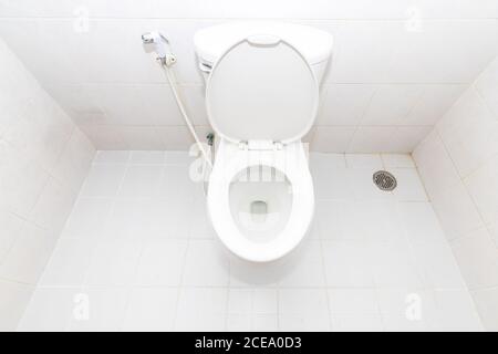 Eine saubere, moderne Toilettenschüssel und aufsteigendes Spray. Draufsicht weiße Toilettenschüssel im Badezimmer. Stockfoto
