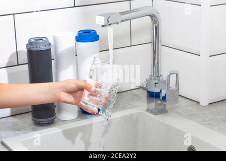 Der Wasserhahn, aus dem das Wasser fließt. Durst löschen. Wasserprobleme in einigen Ländern.das Glas ist mit Wasser gefüllt. Stockfoto