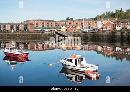 Spiegelungen von Booten im Fluss Tyne und Wohnungen rund um St. Peter's Marina, Newcastle upon Tyne, Nordostengland, Großbritannien Stockfoto