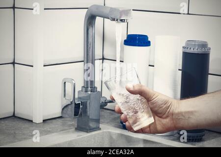 Der Wasserhahn, aus dem das Wasser fließt. Durst löschen. Wasserprobleme in einigen Ländern.das Glas ist mit Wasser gefüllt. Stockfoto