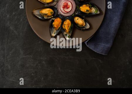 Köstliche Muscheln mit Gemüsescheiben und Granatapfelkernen liegen Auf Platte neben Stoffstück auf grauem Hintergrund Stockfoto