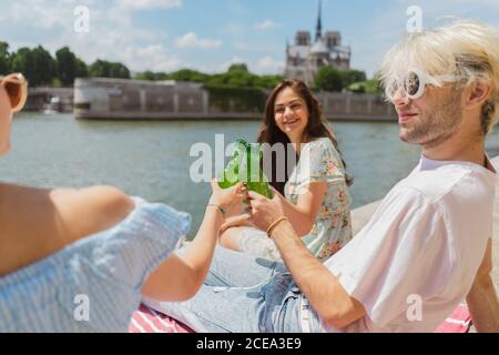 Lächelnde Freunde klirren Flaschen Wasser Stockfoto