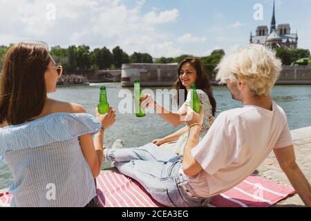 Lächelnde Freunde klirren Flaschen Wasser Stockfoto