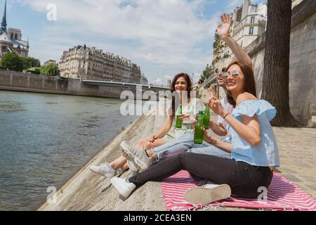 Lächelnde Freunde klirren Flaschen Wasser Stockfoto