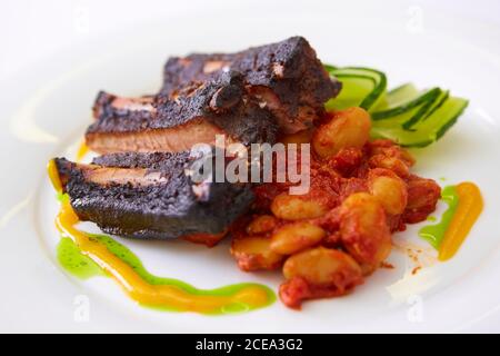 Gegrillte Schweineribs und gebackene Bohnen. Flacher freiheitsgrad Stockfoto
