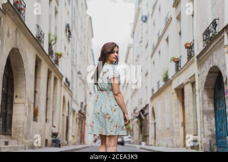 Hübsche junge Frau, die auf einer schmalen Straße läuft Stockfoto
