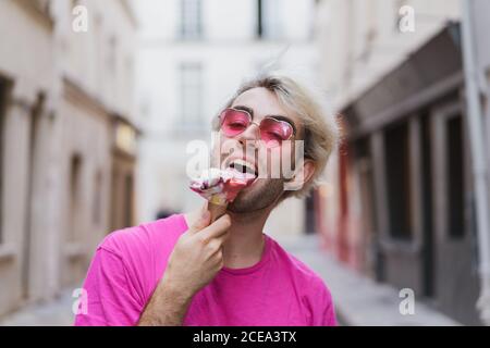 Stilvoller Mann, der auf der Straße Eis isst Stockfoto