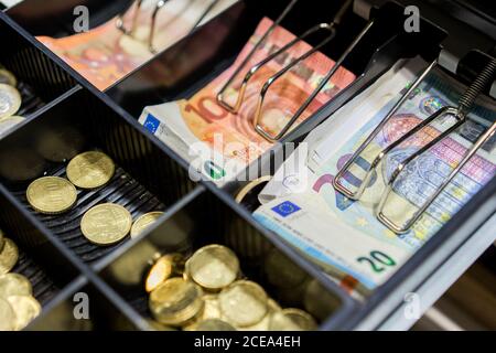 Bargeld und Münzen in der Kasse Stockfoto