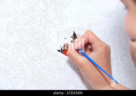 Bild nach Zahlen. Zeichnung auf der Leinwand. Hand mit einem Pinsel. Malerei für Anfänger. Stockfoto