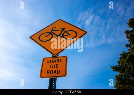 Annapolis, MD 08/21/2020: Bug Blick auf eine gelbe Rhombus-Straßenschild mit einem Fahrrad-Symbol, und eine Platte, die unten, die besagt, "teilen Sie die Straße Stockfoto