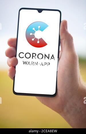 WETZLAR; DEUTSCHLAND 2020-08-26, CORONA APP Offizielle deutsche Corona Warning App auf Handy von Hand gehalten auf verschwommenem Hintergrund Stockfoto