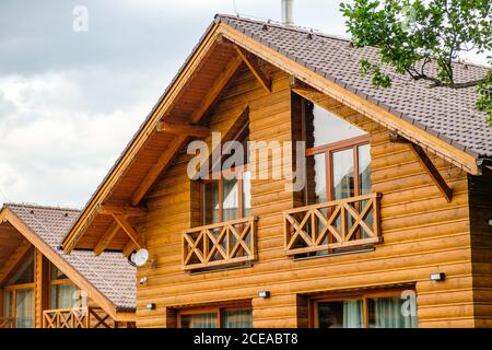 Modernes Holzhaus mit großen Fenstern und Balkon. Konzept des Baus von Familienhäusern, Pensionen oder Hütten auf dem Land. Bau von Häusern Stockfoto
