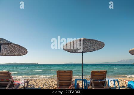 Sandstrand in Çeşme mit Strohschirmen und Liegestühlen als sehr schöner Hintergrund. Stockfoto