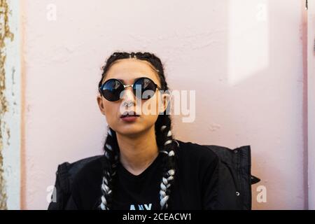 Trendige Brünette mit Piercing tragen Sonnenbrille Blick zuversichtlich in die Kamera Stockfoto