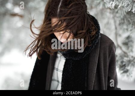 Junge Frau in warmen Kleidern zu Fuß an windigen Wintertag In herrlicher Landschaft Stockfoto