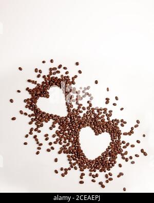 Kaffeebohnen auf weißem Hintergrund in Herzform. Stockfoto